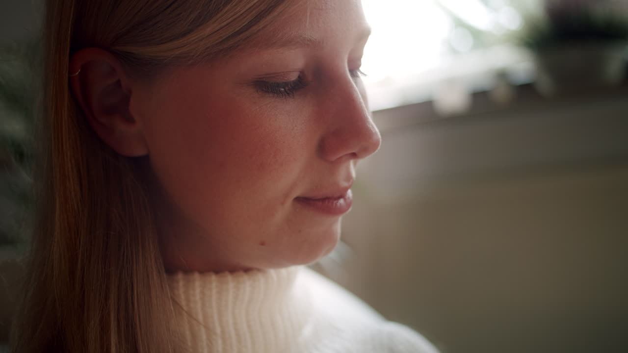 hermosa joven rubia disfrutando de un buen libro en la sala de estar, acogedora