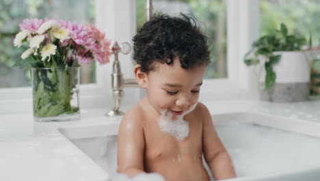 bebé feliz bañándose niño pequeño divertido bañándose en el fregadero de la cocina divirtiéndose con burbujas de jabón 4k