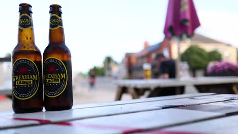 two beer bottles on a table outdoors