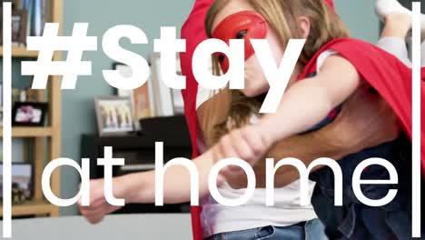 animation of the words ~ stay at home over happy girl and her father wearing superhero capes at home