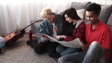 grupo de amigos diversos mirando el mapa en la habitación brillante