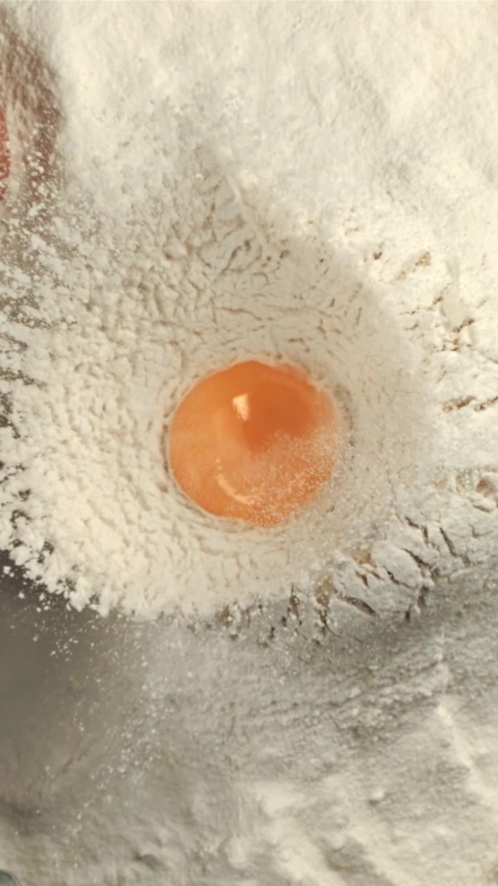 Egg Yolk Dropping into White Flour in Slow Motion