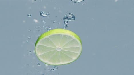 Lime-slices-are-thrown-into-water,-one-of-them-shows-up-longer