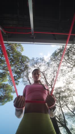 mujer haciendo ejercicio al aire libre con banda de resistencia