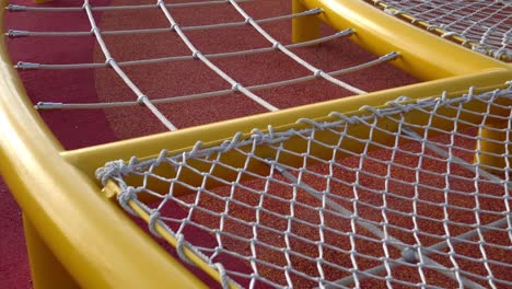 climbing net in the park. game equipment for children. tilt shot from top to bottom. the subject is on the left.