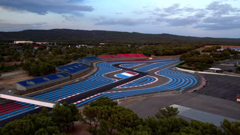 Modern-racetrack-design-featuring-bold-blue-stripes,-adjacent-to-green-spaces