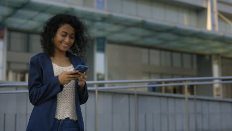 Woman using a smartphone in front of a modern building