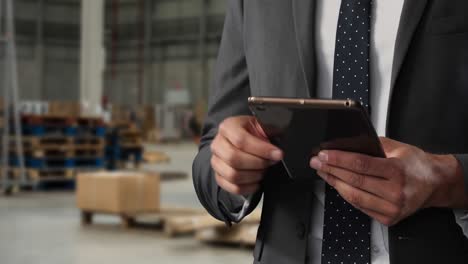 hombre de negocios caucásico usando una tableta digital en un almacén