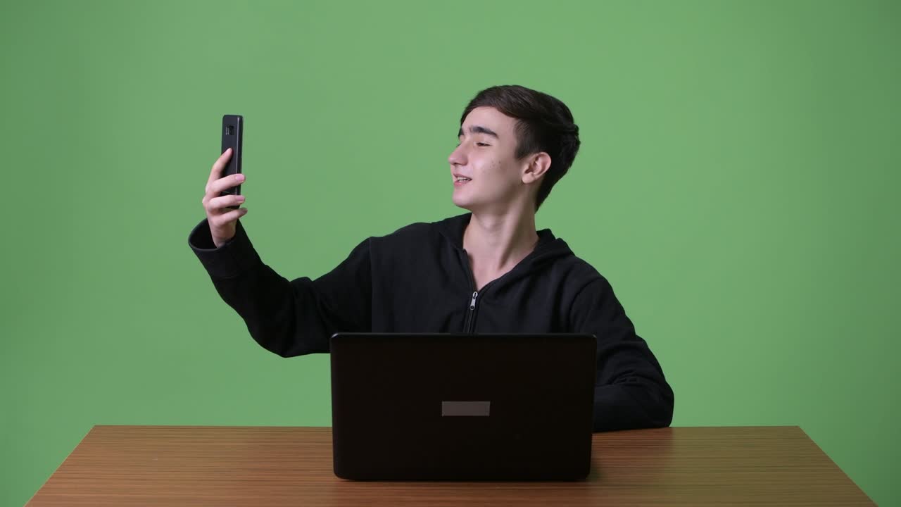 초록색 배경에 젊은 잘생긴 이란 십대 소년