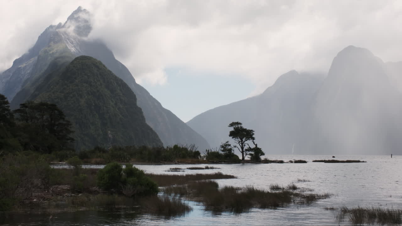 A veil of mist delicately drapes the majestic peaks of Milford Sound
