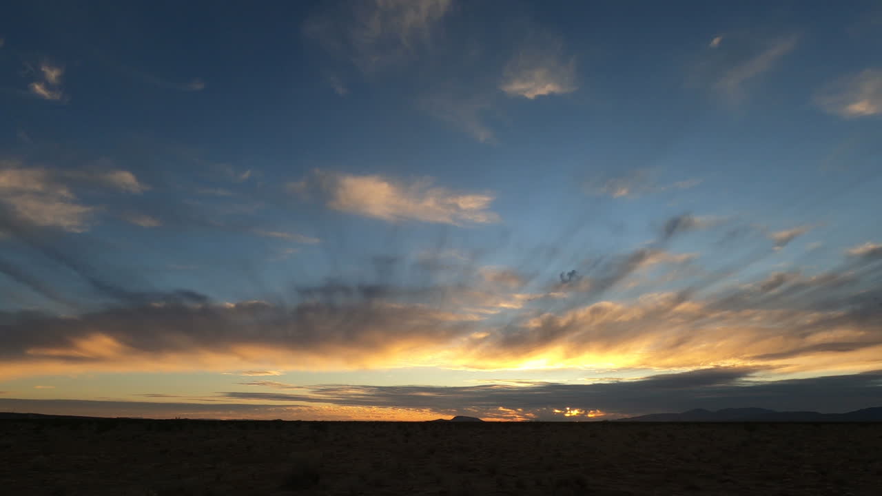 Day to Night Timelapse with Blue, Orange, and Red Colors in Cloudy Sky
