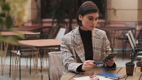 Joven-Empresaria-Haciendo-Pagos-En-Línea-En-Un-Teléfono-Inteligente-Durante-La-Pausa-Para-El-Café.