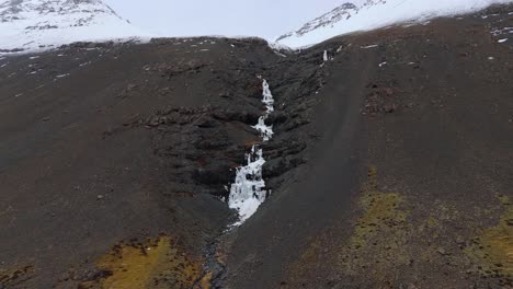 cascada de skutafoss congelada que cae en cascada desde las montañas glaciares nevadas