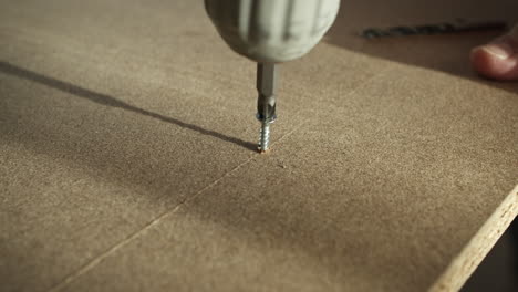 Extreme-Close-up-of-Screwing-into-Wooden-Board-with-Power-Drill-in-slow-mo