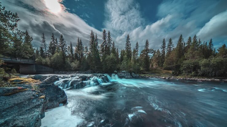 Nuvole scure e tempestose turbinano sopra le rapide sul fiume impetuoso