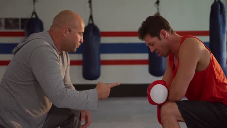 caucasian man coaching athlete in boxing gym