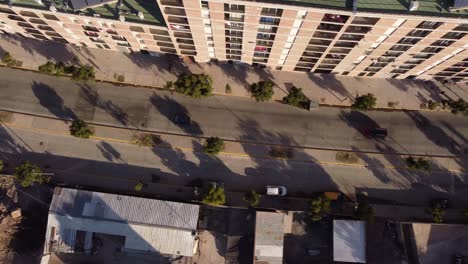 aerial overhead tracking shot of cars driving on road at chacarita area in buenos aires during sunset