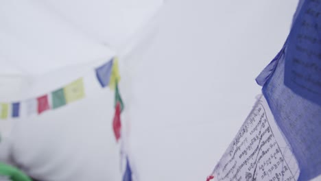 hanging colorful fabric flags surrounded inside white tent. - close up