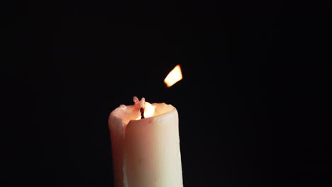 las vitrinas de coloridas velas individuales sobre fondo negro con el efecto de la luz y la cámara lenta