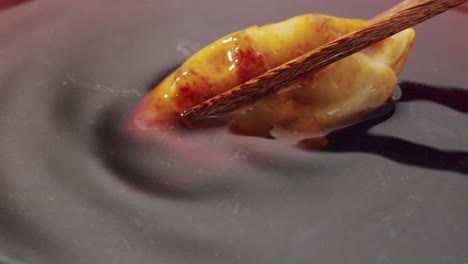 dipping a dumpling in sauce