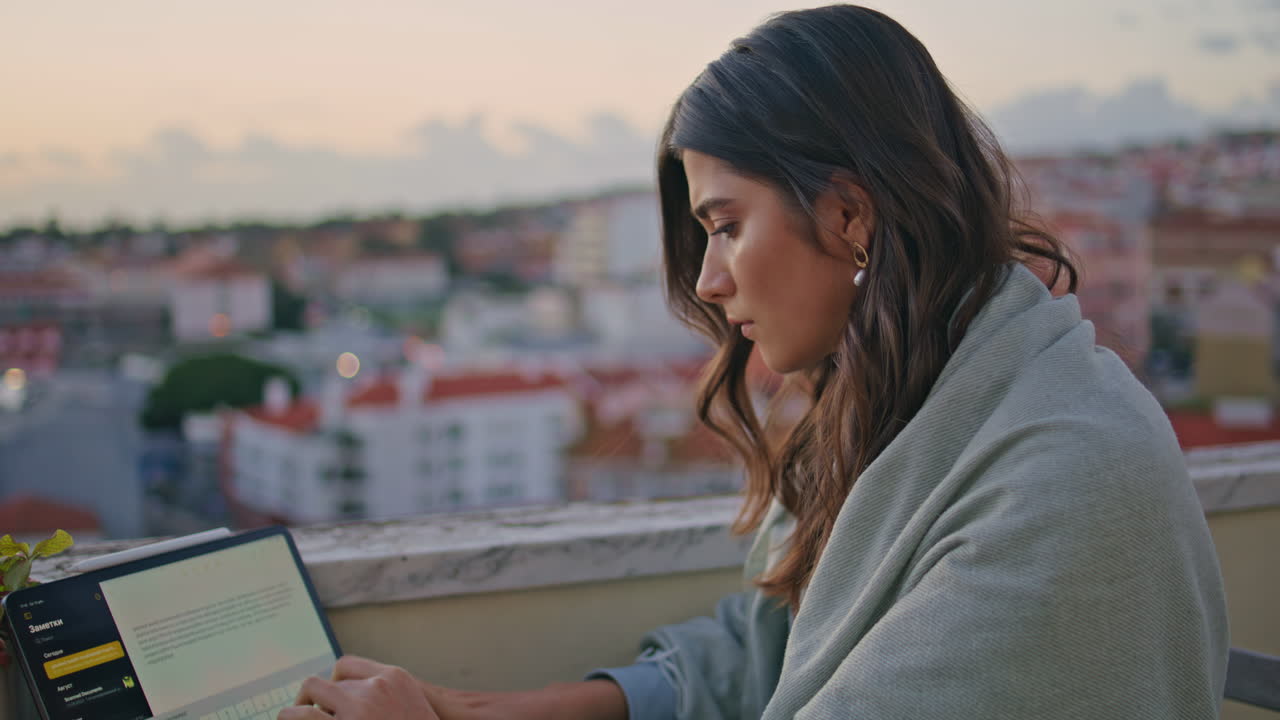 niña enfocada escribiendo diploma portátil en la ciudad de la puesta del sol panorama primer plano. señora escribiendo
