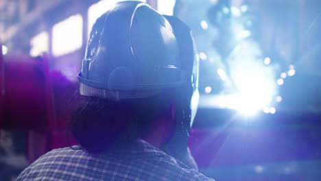 worker with welding helmet in factory