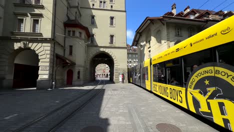 yellow tram on cobblestone street in bern, switzerland