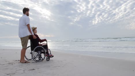 side view of young caucasian couple looking at sea on the beach 4k