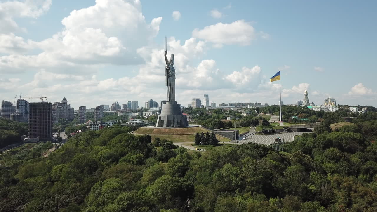 imágenes aéreas de drones de 4k del monumento a la patria de ucrania junto con la enorme bandera ucraniana en un día nublado de verano