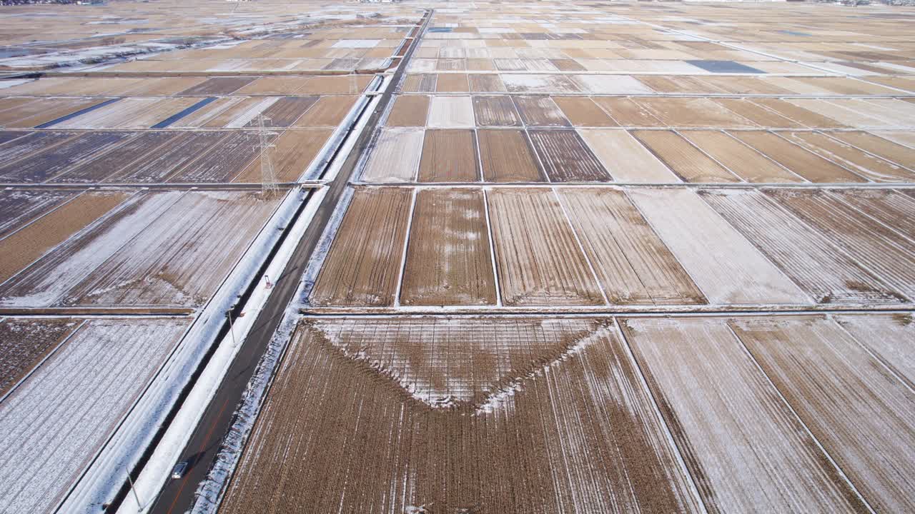 Winter countryside landscape in Japan seen from above with snow-covered agricultural plots