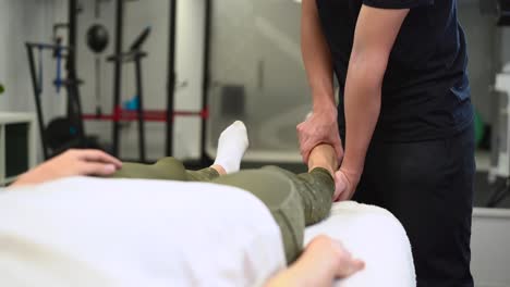 crop therapist massaging foot of patient in clinic