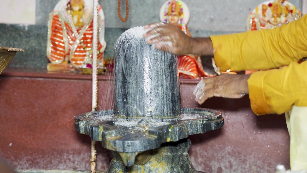 Rituale tradizionale indù di adorazione di Shiva con Lingam sacro e divinità del tempio