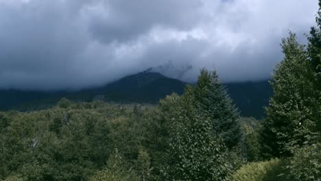las nubes oscuras descansan en el monte washington mientras se ve el humo del tren de cremallera