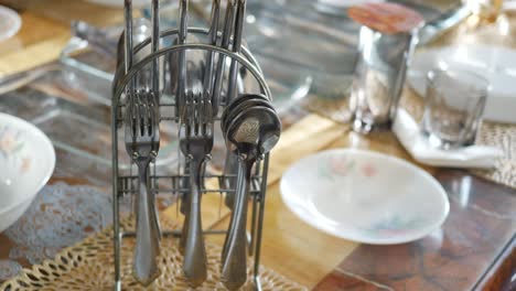 close-up of silverware in a metal holder on a table