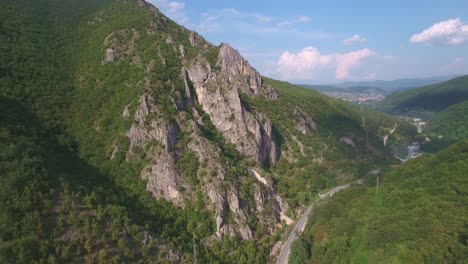 mountain next to road outside of novi pazar in serbia europe on a sunny day, aerial forward