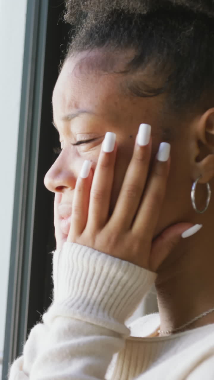 Video of crying african american woman looking outside window
