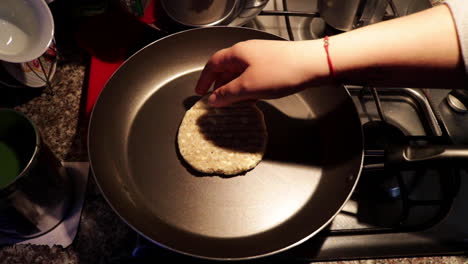 persona que comienza a cocinar quinua en una sartén en casa