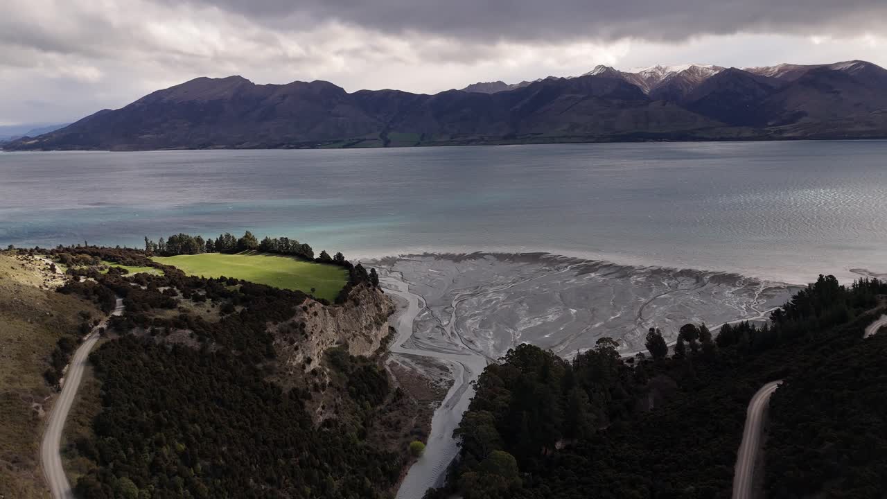 Aerial documentary over the stunning turquoise waters of Lake Hawea, South Island, New Zealand with crystal-clear glacial lake surrounded by Southern Alps