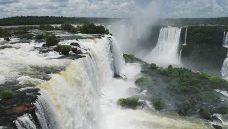 blick von oben auf einen großen wasserfall, der in den regenwald fällt, ein pool in farbenfroher grüner dschungellandschaft, wunderschönes, glänzendes wasser in den iguazu-fällen, brasilien, südamerika