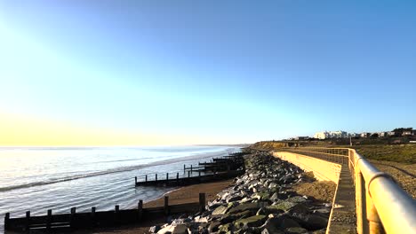 Britischer-Strand-Mit-Ruhigen-Wellen-Und-Sonnenbeschienenen-Kieselsteinen