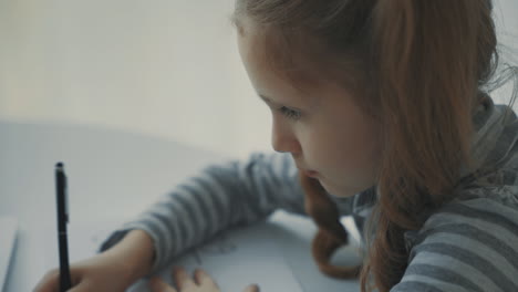 una niña haciendo su tarea en casa