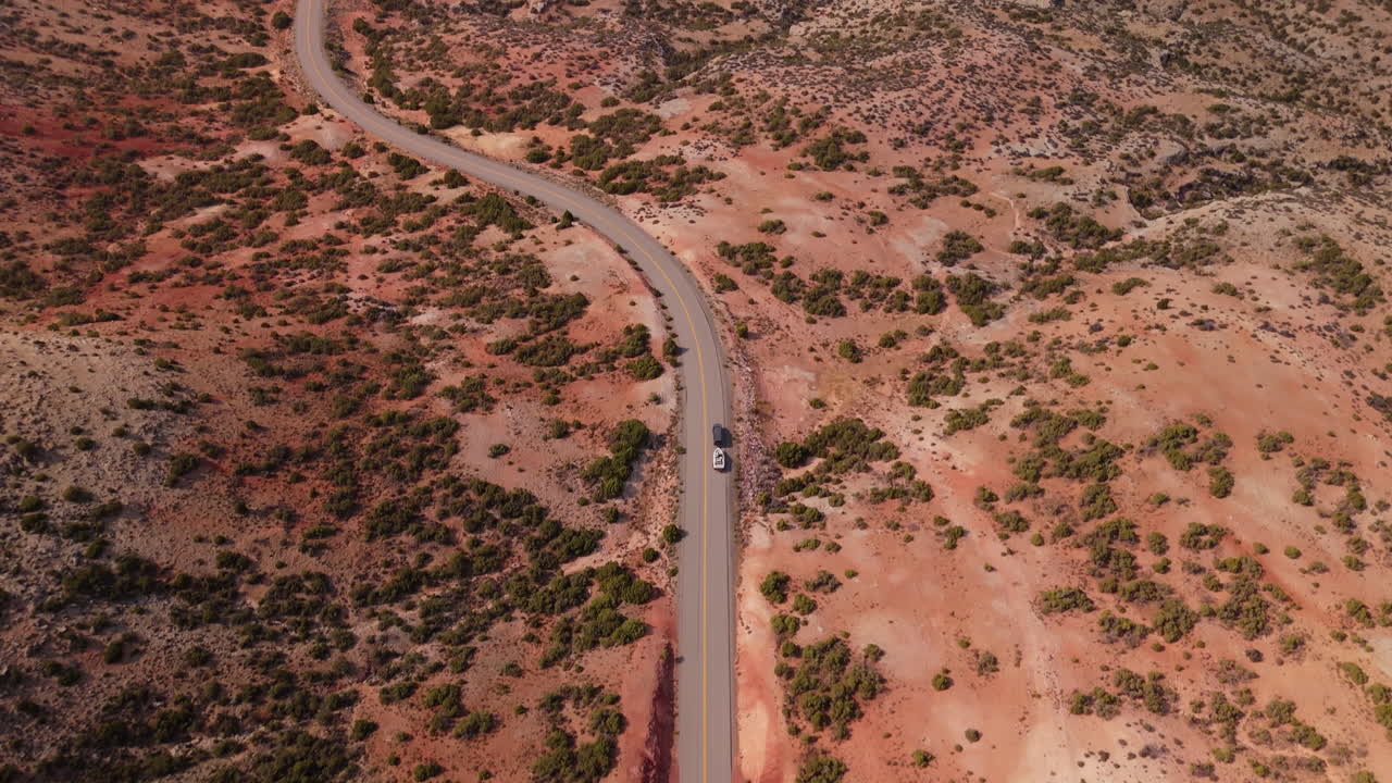 Aerial view of a winding road through a colorful desert landscape
