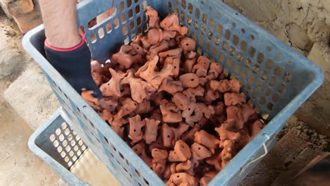 Top-view-of-crate-with-asian-clay-animal-figurines-placed-hand-by-hand