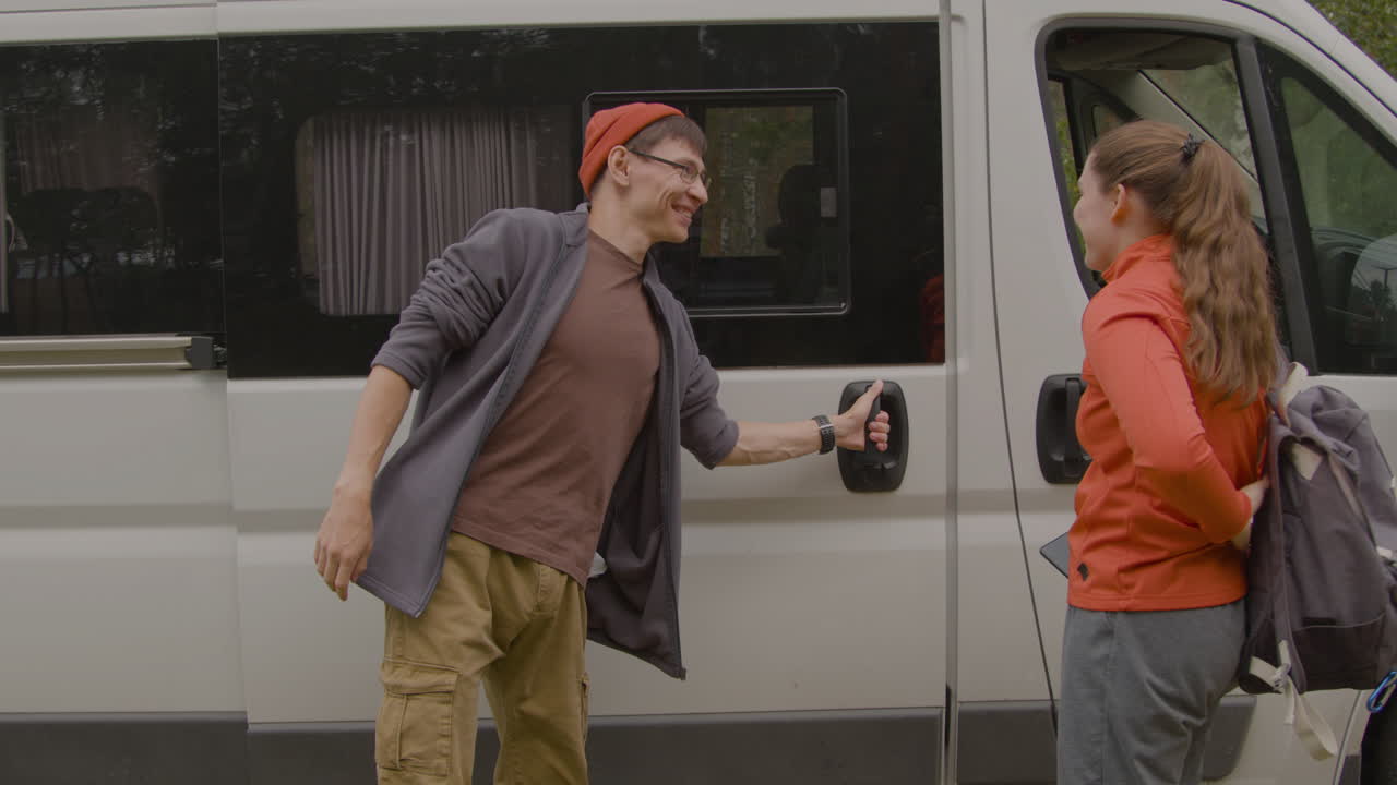 두 사람이 밴에서 내려오고 있습니다.