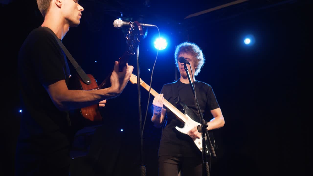 콘서트 록 밴드, 두 개의 전기 기타와 함께 무대에서 공연하는 가수, 뮤직비디오 크, 헤비 메탈 또는 록 그룹, 느린 동작 악기 연주 두 사람의 밴드