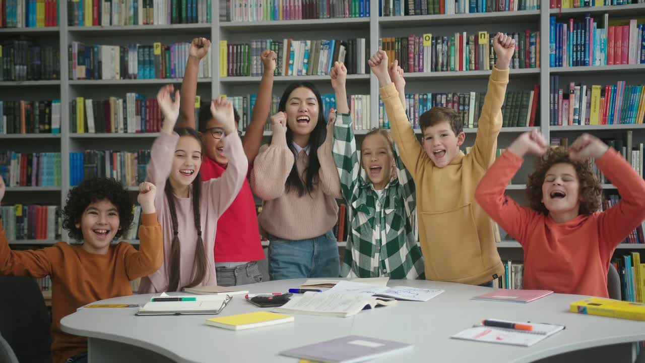el maestro feliz y los escolares levantaron las manos en la biblioteca.