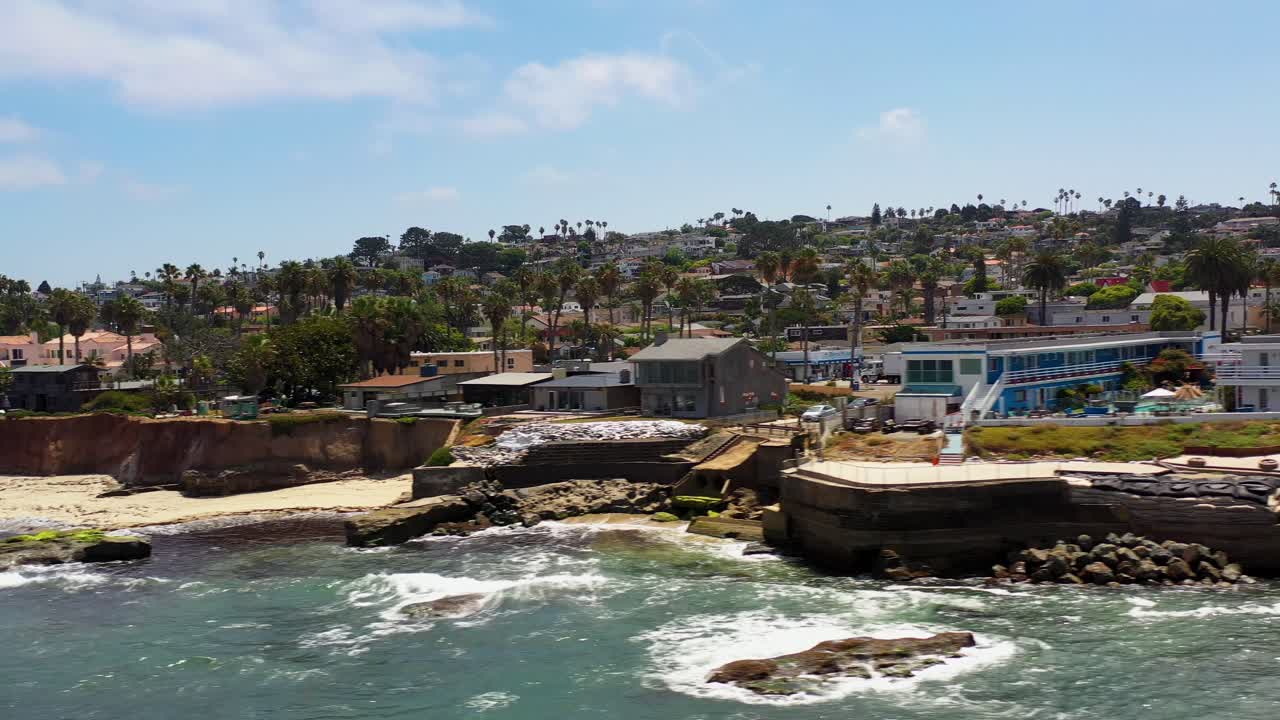 Dron volando lateralmente a lo largo de los acantilados en Ocean Beach, San Diego, capturando vistas de la costa y el océano desde una perspectiva lateral.
