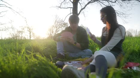 couple playing cards in a park