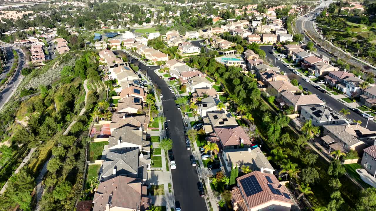 avión volando sobre el vecindario de viviendas suburbanas de santa clarita en una tarde soleada