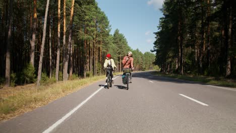 una pareja en bicicleta a través de un bosque.